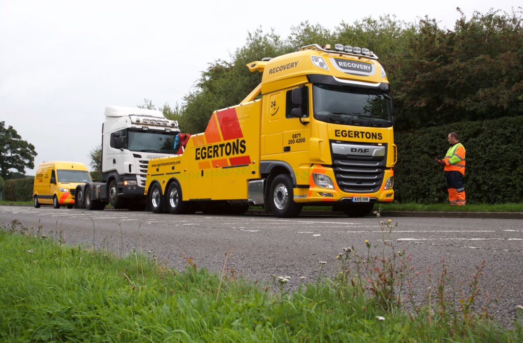 Egertons heavy recovery truck towing a lorry on a roadside verge.