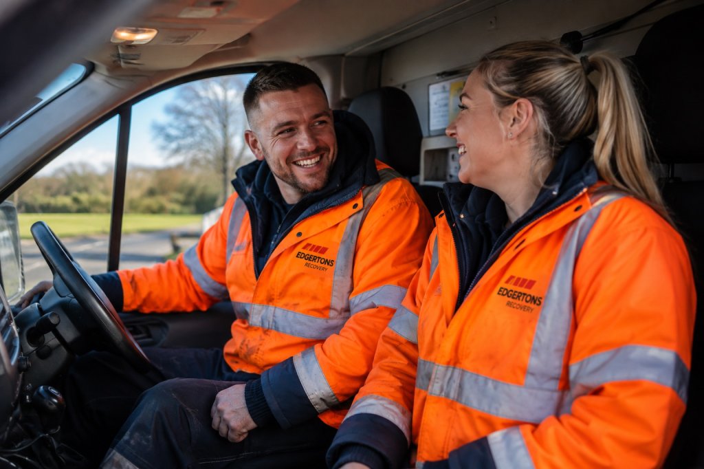 Two Egertons team members in high-visibility jackets smiling in a van cab.