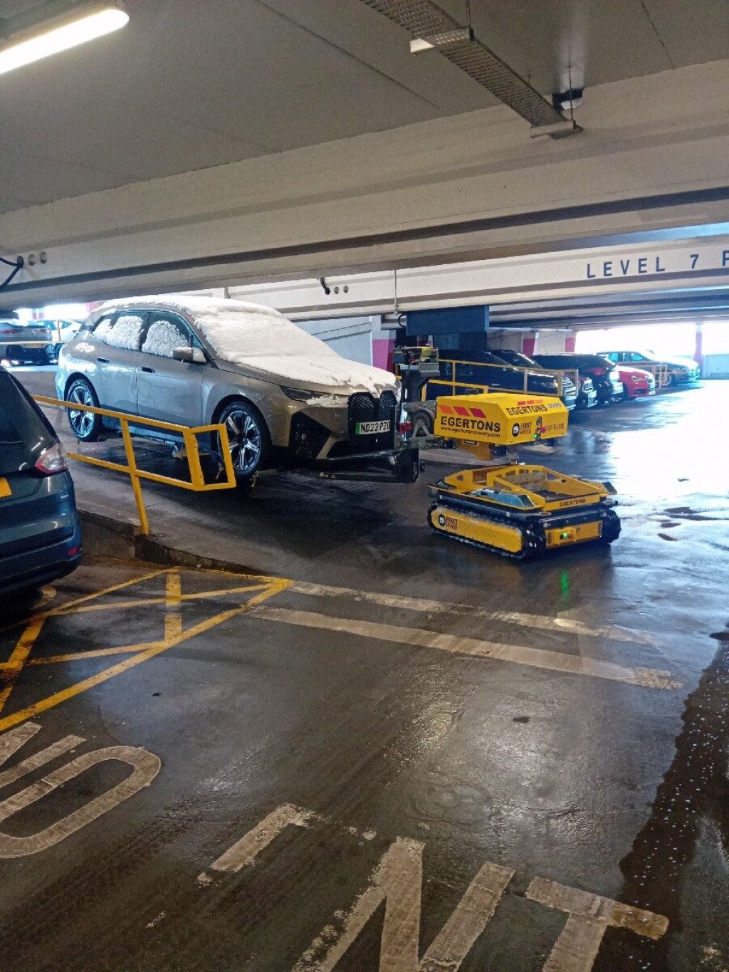 Electric vehicle being charged in a car park.