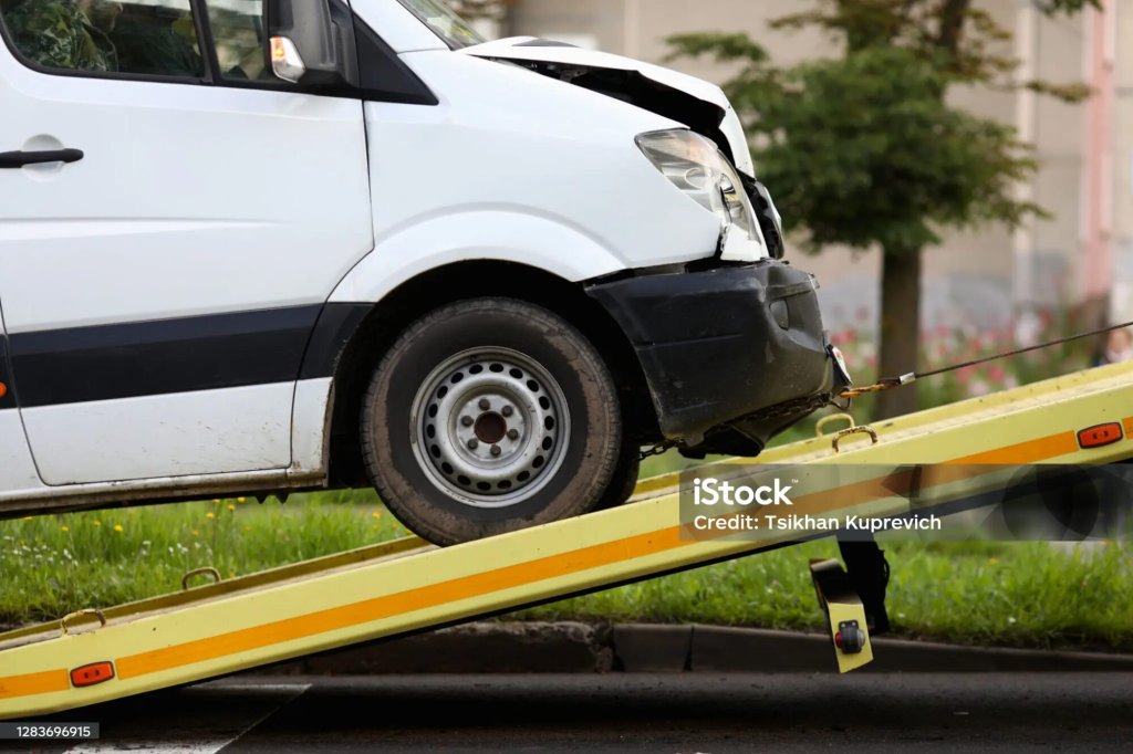 Damaged van loaded onto a recovery truck.