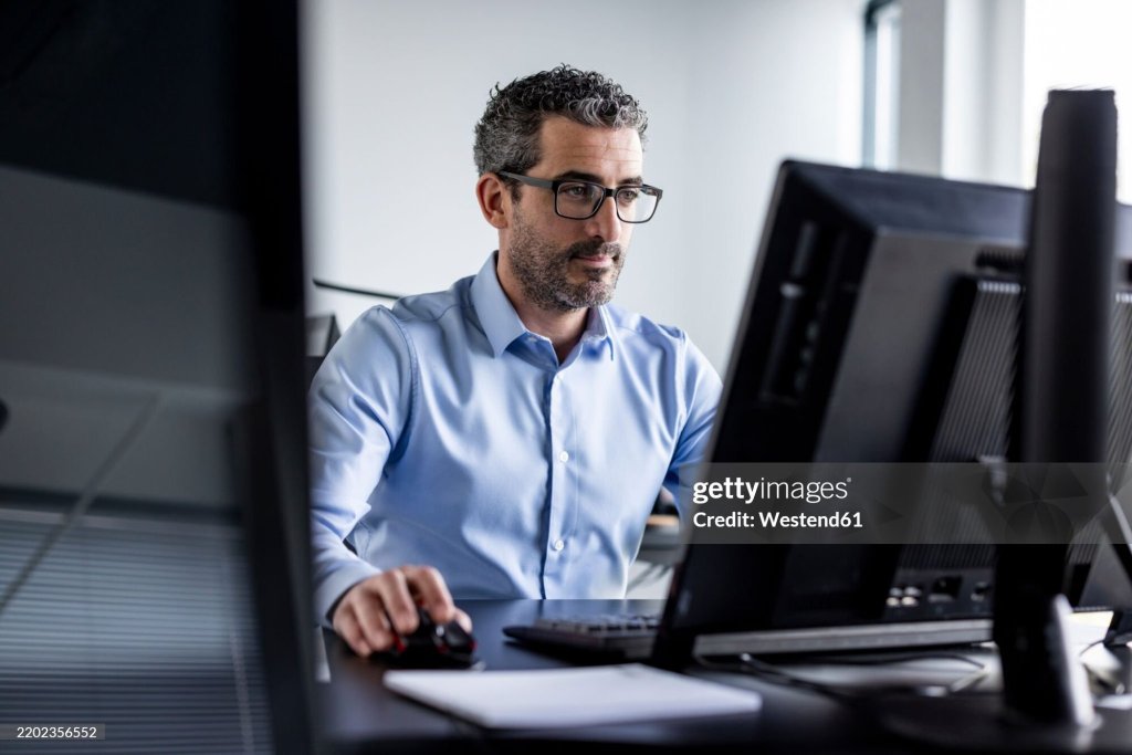 Warranty administrator working at a computer.