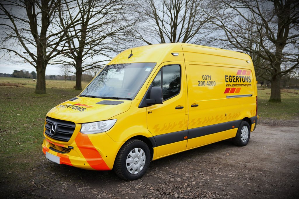 Egertons yellow roadside repair van parked by trees.