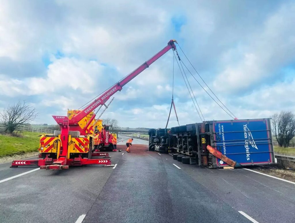 Rotating crane recovering an overturned HGV on a motorway.